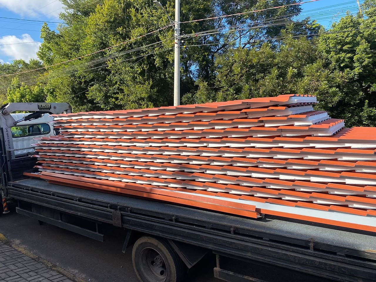 Caminhão carregado de telha sanduíche de aluzinco cortada sob medida para entrega regional