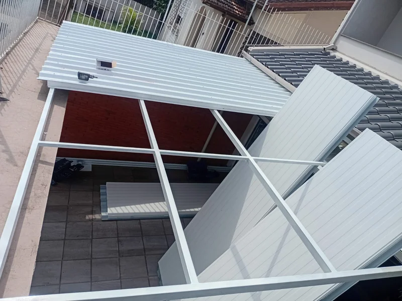 Instalação de telha trapezoidal em aluzinco em andamento, estrutura sendo fixada